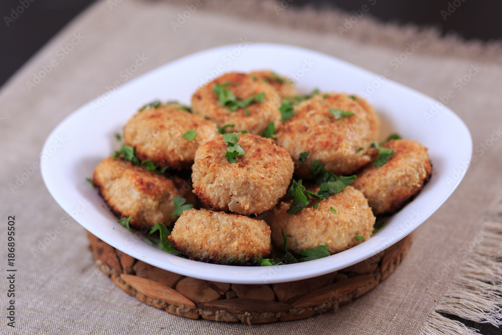 Fried cutlets on a white plate on a table on a gray background. Fried cutlets on a white plate on a table on a gray background.