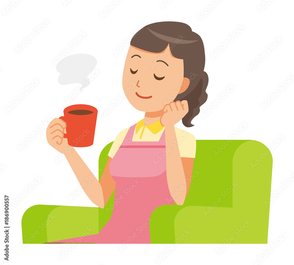 A female home helper wearing an apron sits on the sofa and is drinking coffee A female home helper wearing an apron sits on the sofa and is drinking coffee