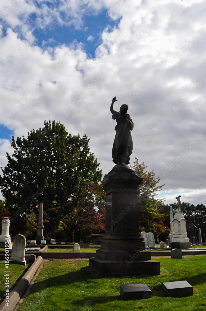 Silhouette of an Angel Statue Pointing Up to Heaven in a Cemetery