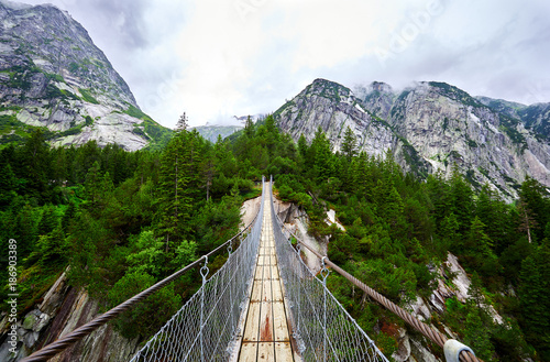 Suspension bridge in mountains photo