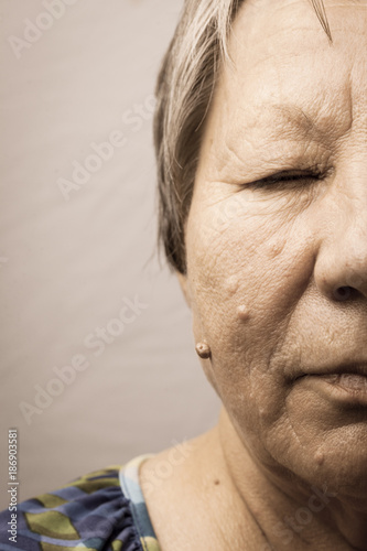 Elderly pensioner female half face portrait closeup photo