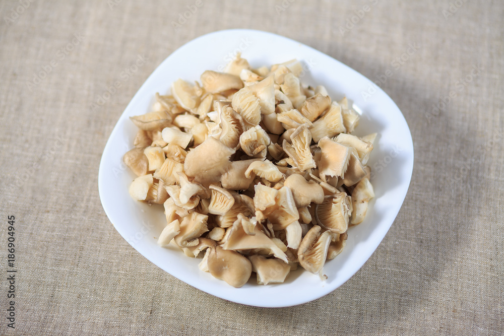 Marinated mushrooms champignons on a plate on a gray background Marinated mushrooms champignons on a plate on a gray background