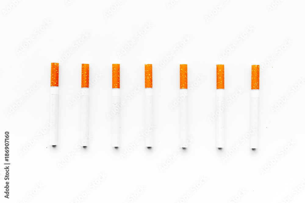 Tobacco. Row of cigarettes on white background top view Tobacco. Row of cigarettes on white background top view