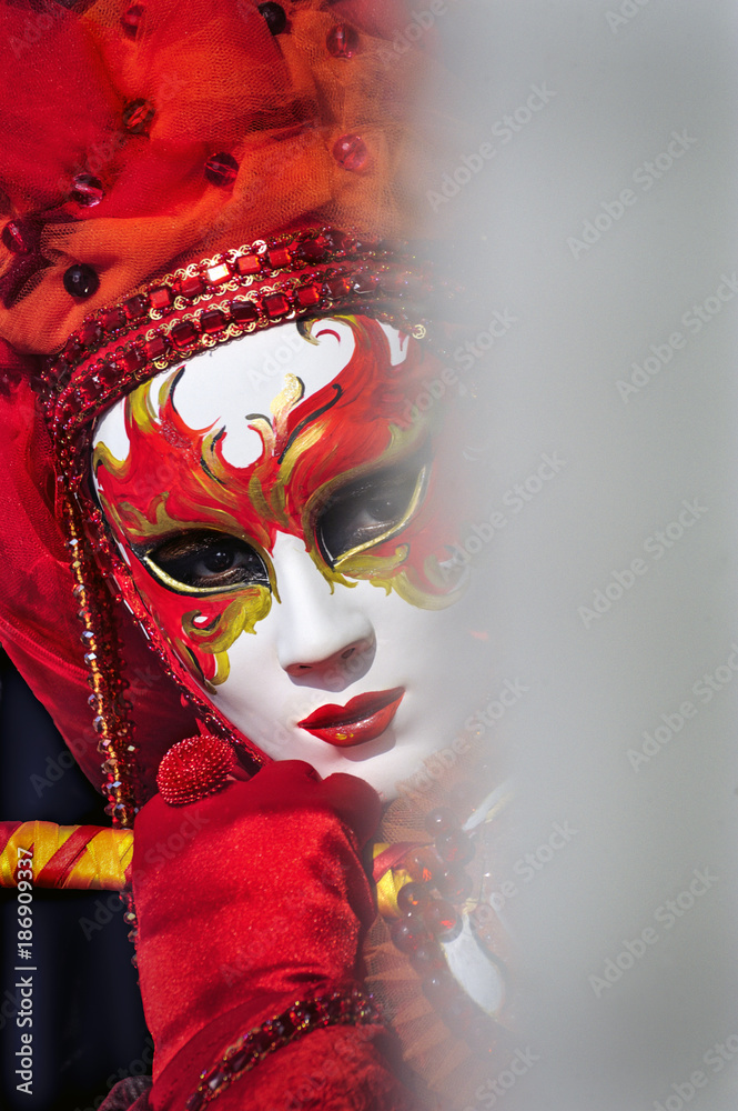 Weiße, rot verzierte weibliche Maske beim Karneval in Venedig