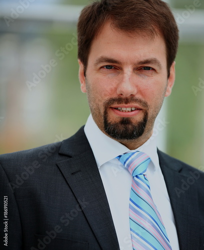 Smiling businessman with arms crossed at office