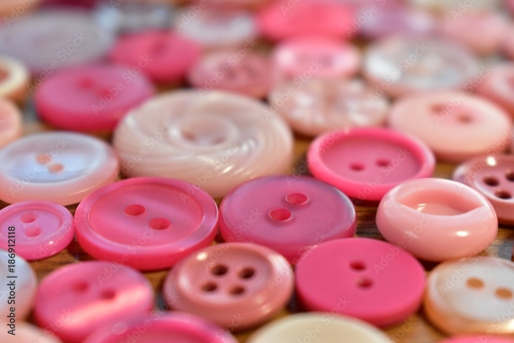 bright pink sewing button on a wood table bright pink sewing button on a wood table
