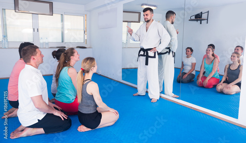 Karate instructor is showing new martial moves to adults