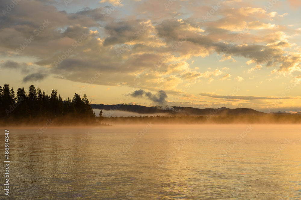 Morning Misty Lake - Colorful clouds and morning fog over Yellowstone Lake, Yellowstone National Park, Wyoming, USA.