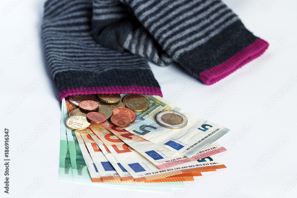 Geld in Socken verstecken. Die Socken als Sparschwein für Euros Stock-Foto  | Adobe Stock