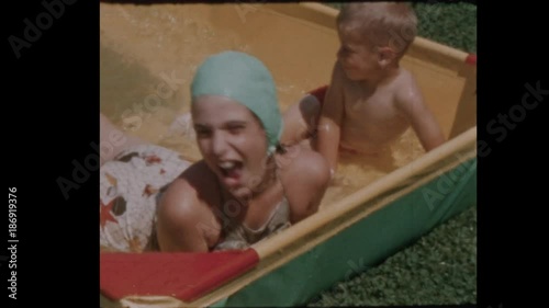 1956 Little boy and girl play in kiddie pool  Close Up 
