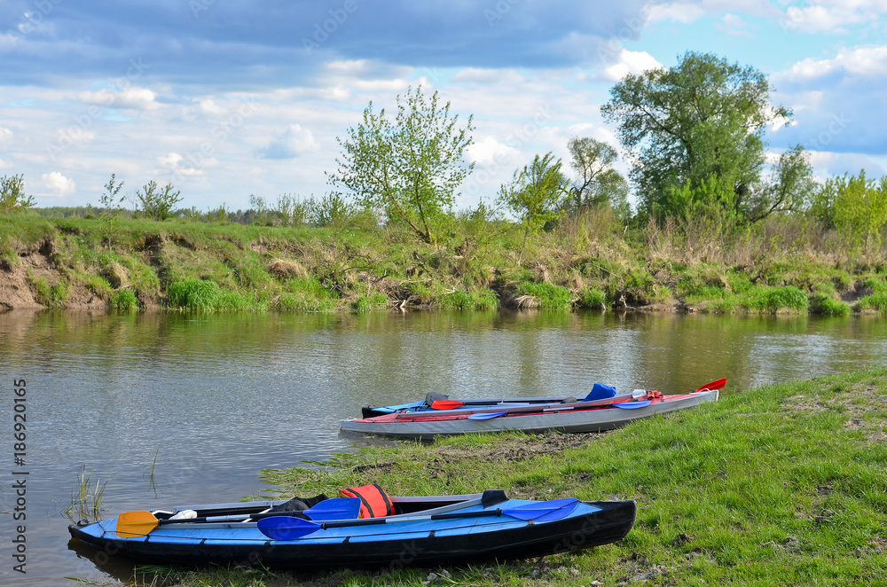 Canoes on the river bank at beautiful weather in summer. Canoes on the river bank at beautiful weather in summer.