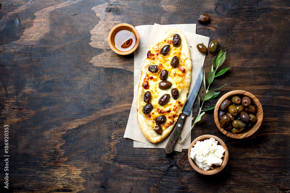 Homemade oval pizza with whole olives and cheese. Top view, copy space