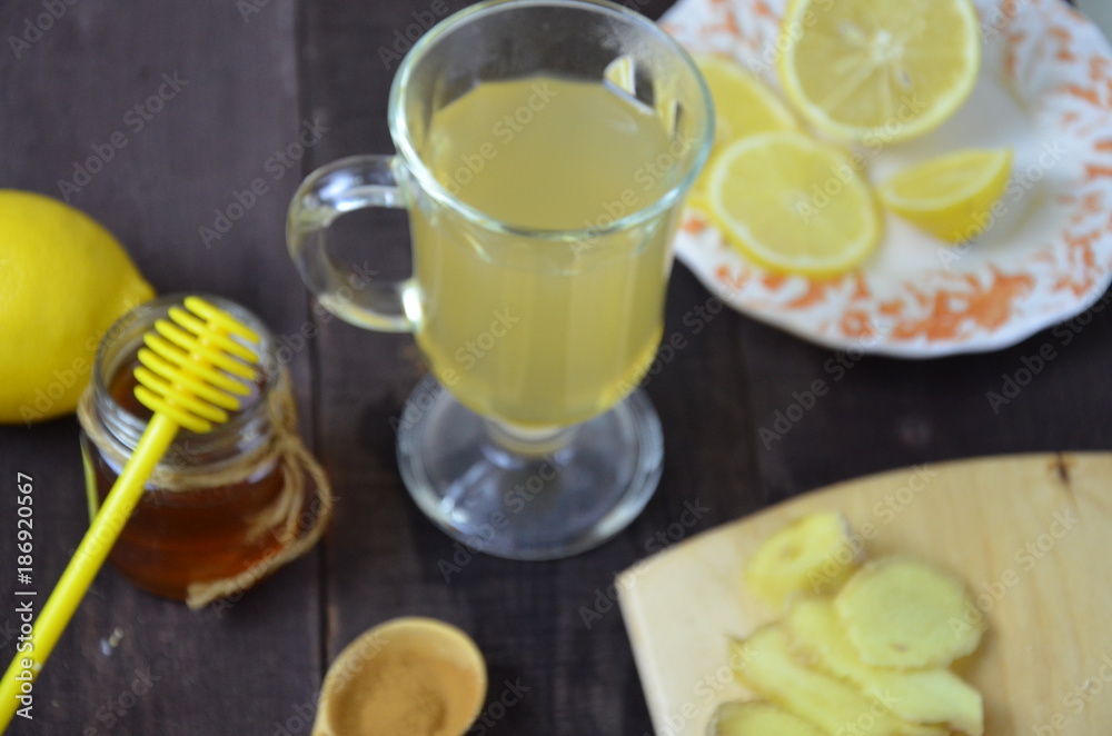 Hot drink with honey, lemon and ginger for cough remedy on wooden table Hot drink with honey, lemon and ginger for cough remedy on wooden table