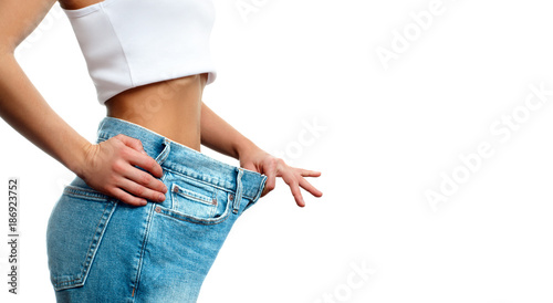 Woman in oversize jeans after weight loss.