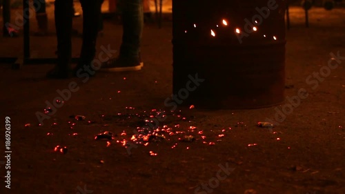 Troubled teenagers hanging out in street at night, warming near fire, gang