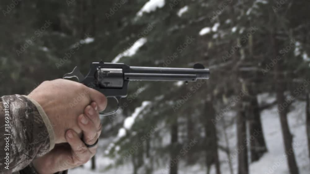 Man in hunting clothing aims and shoots his revolver gun, various framing from medium to close up shot, with sound.