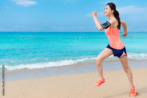 young happy female runner carrying earphones