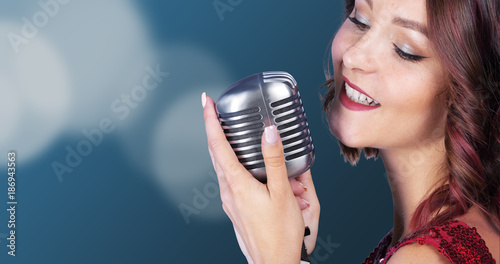 Beautiful and stylish woman singerwith a microphone
