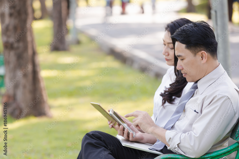 Fototapeta premium Asian two business men and woman work relaxation in park with laptop
