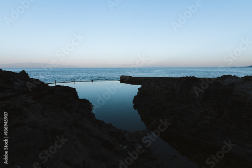 Calm water in natural pool near ocean at dawn