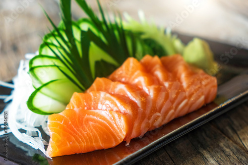 Sashimi, Salmon, Japanese food chopsticks and wasabi on the wood table 