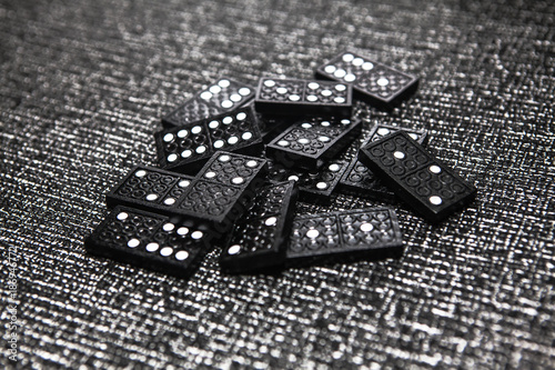 pile of black dominoes ready for game on grey background