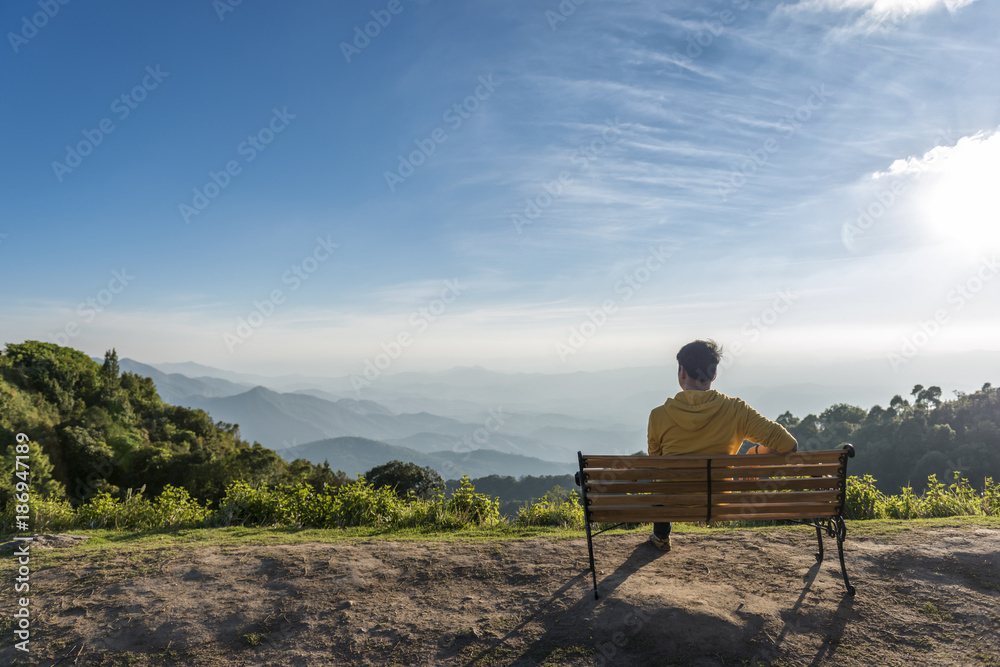 Traveler man siting wooden bench with Mountains Traveler man siting wooden bench with Mountains
