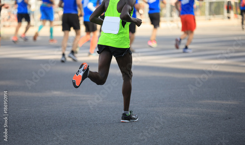marathon runner legs running on city road © lzf