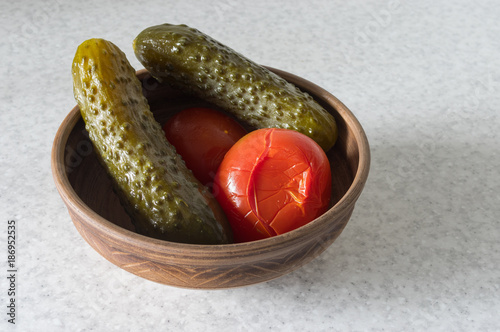 Ukrainian traditional appetizer - sour cucumbers and tomatoes in earthenware