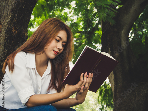 Young woman reading book at the park.