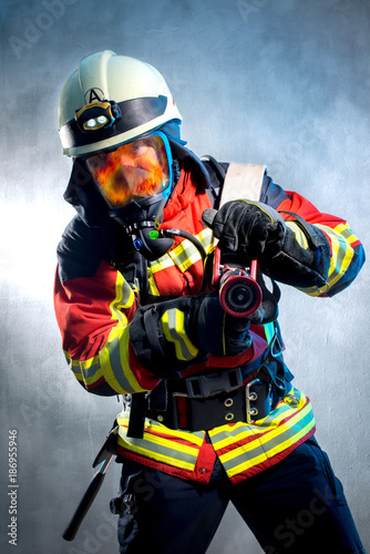 Feuerwehrmann bei der Brandbekämpfung, Flammen spiegeln sich in der Atemschutz Maske © Werner