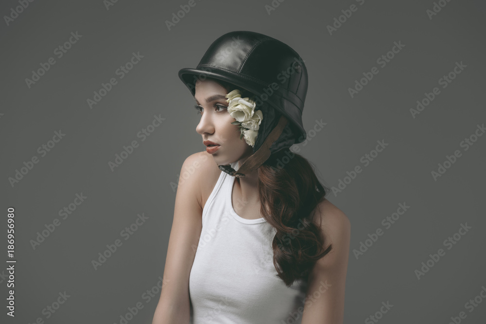 beautiful young girl in military helmet with white roses, isolated on grey beautiful young girl in military helmet with white roses, isolated on grey