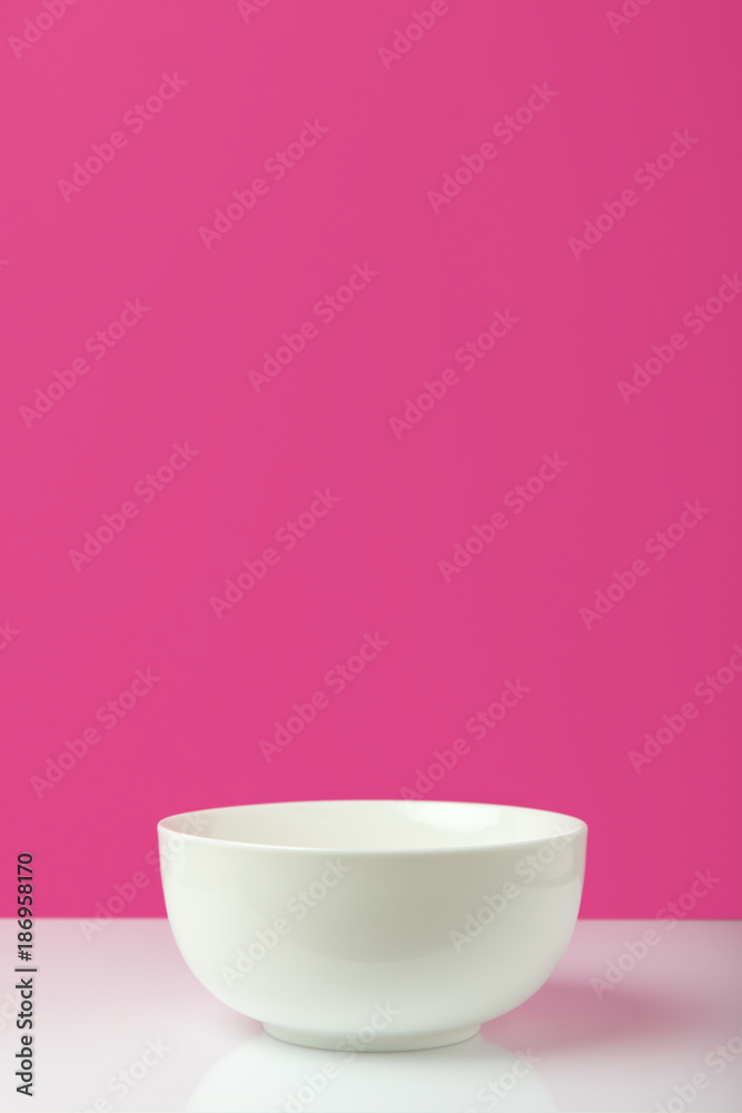 close-up view of empty white bowl with copy space on pink close-up view of empty white bowl with copy space on pink