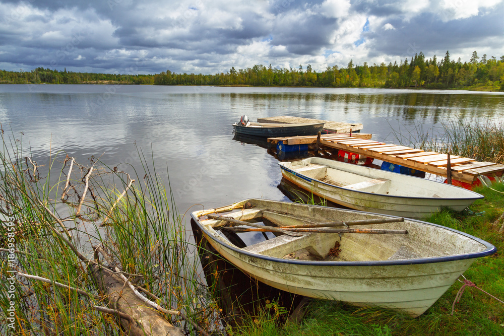 Obraz premium Idyllic lake scenery with boats in cloudy day, Sweden