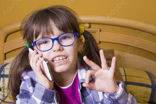 girl with the mobile phone and doing ok sign photo