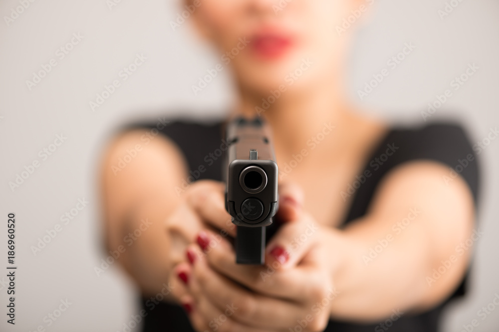 young woman asian girl holding a gun aiming at the gun, with selective focus young woman asian girl holding a gun aiming at the gun, with selective focus