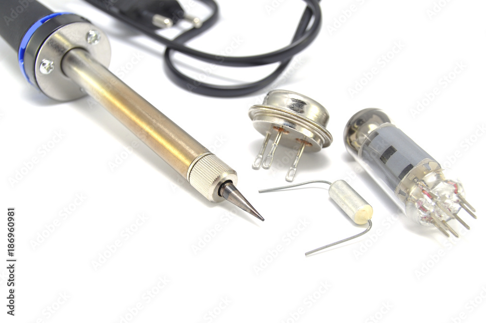 Radio components and electric soldering iron on white background close-up Radio components and electric soldering iron on white background close-up
