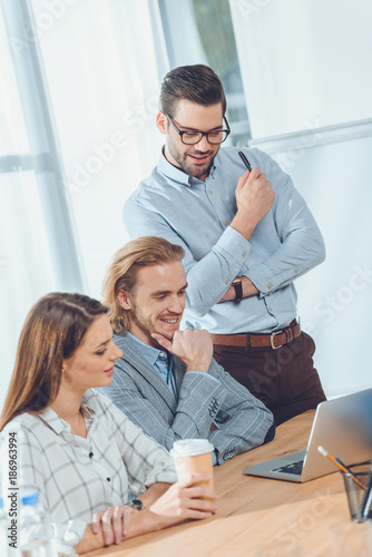 business team looking on laptop on table at office space