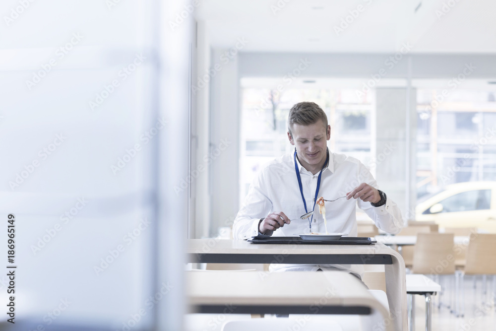 Young man in a canteen for diner Young man in a canteen for diner