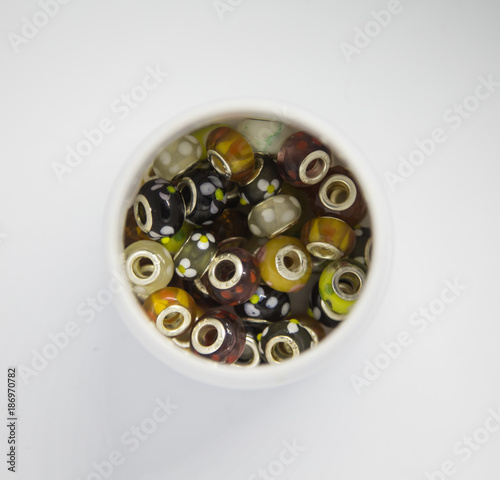 Beautiful colorful jewelry making beeds on white background. Shallow depth of field. Hand craft supplies.
