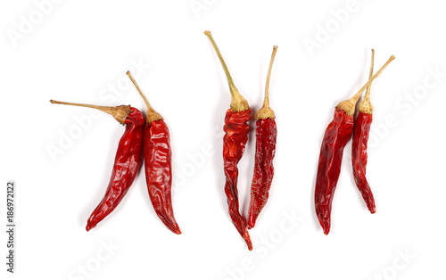 Dry red hot chili peppers, pile isolated on white background, top view