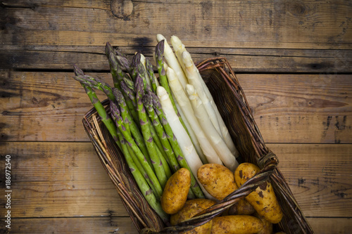 White and green asparagus and new potatoes in wicker basket