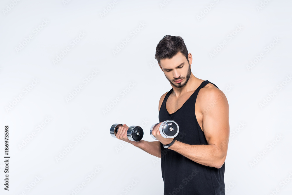 muscular young man working out with dumbbells isolated on white muscular young man working out with dumbbells isolated on white