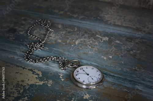 Old pocket watch showing five to twelve photo