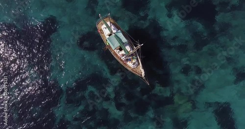 Aerial, a lonely sailing ship in a beautiful bay with crystalline water