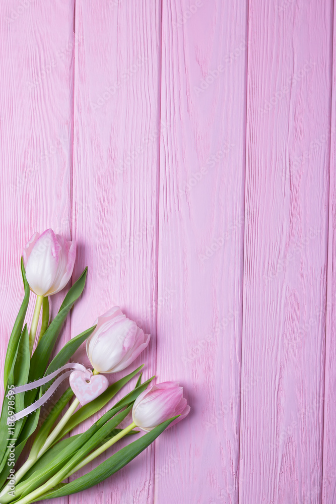 Valentine's day concept. Valentine's day background. Pink tulips and heart on a pink background. Top view, free space