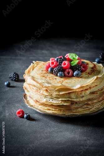 Big pancakes cake with fresh berries and mint