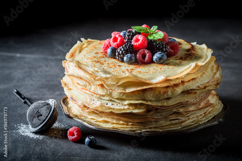 Big stack of pancakes with blueberries and raspberries