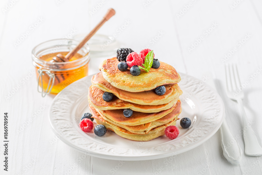 Sweet and tasty american pancakes with maple syrup and berries Sweet and tasty american pancakes with maple syrup and berries