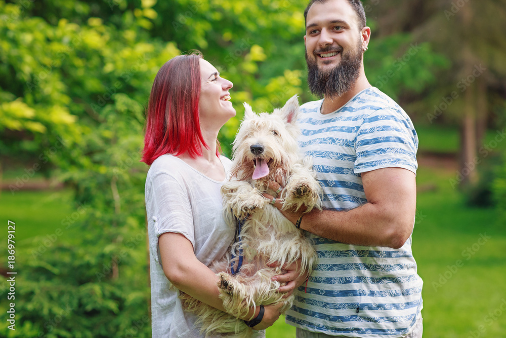 Couple having fun while walking with dog in park Couple having fun while walking with dog in park